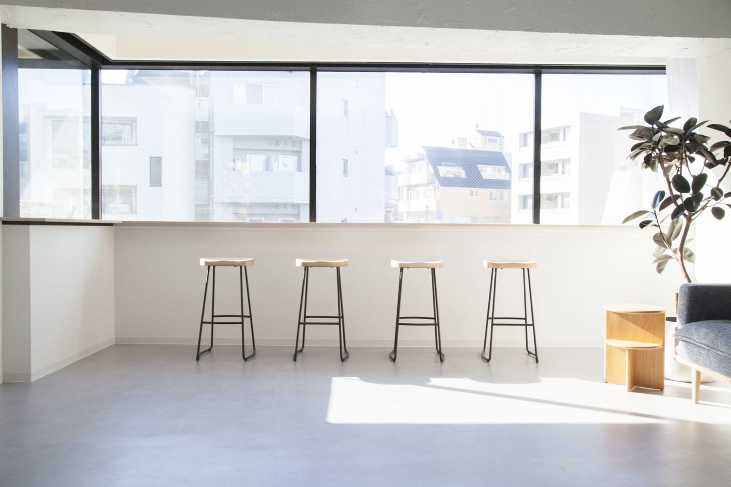 窓にカウンターテーブルとハイスツール