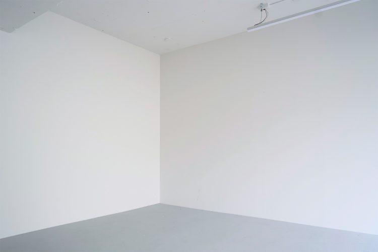 グレーに近い白壁と、モルタル白塗装の床