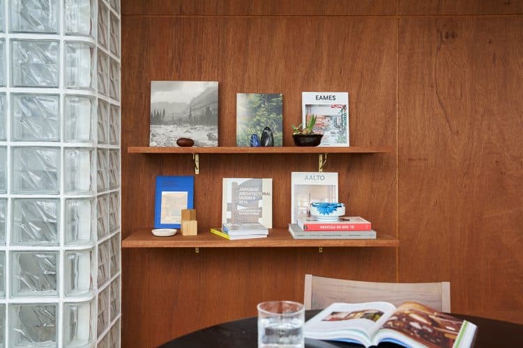 ウッド壁の棚に並ぶセレクトされた写真集やアート作品