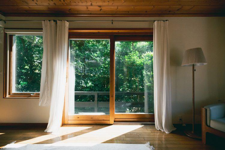 木製サッシの窓から見える庭の緑