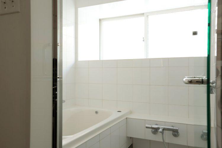 白いタイル張り・ガラス扉のバスルーム